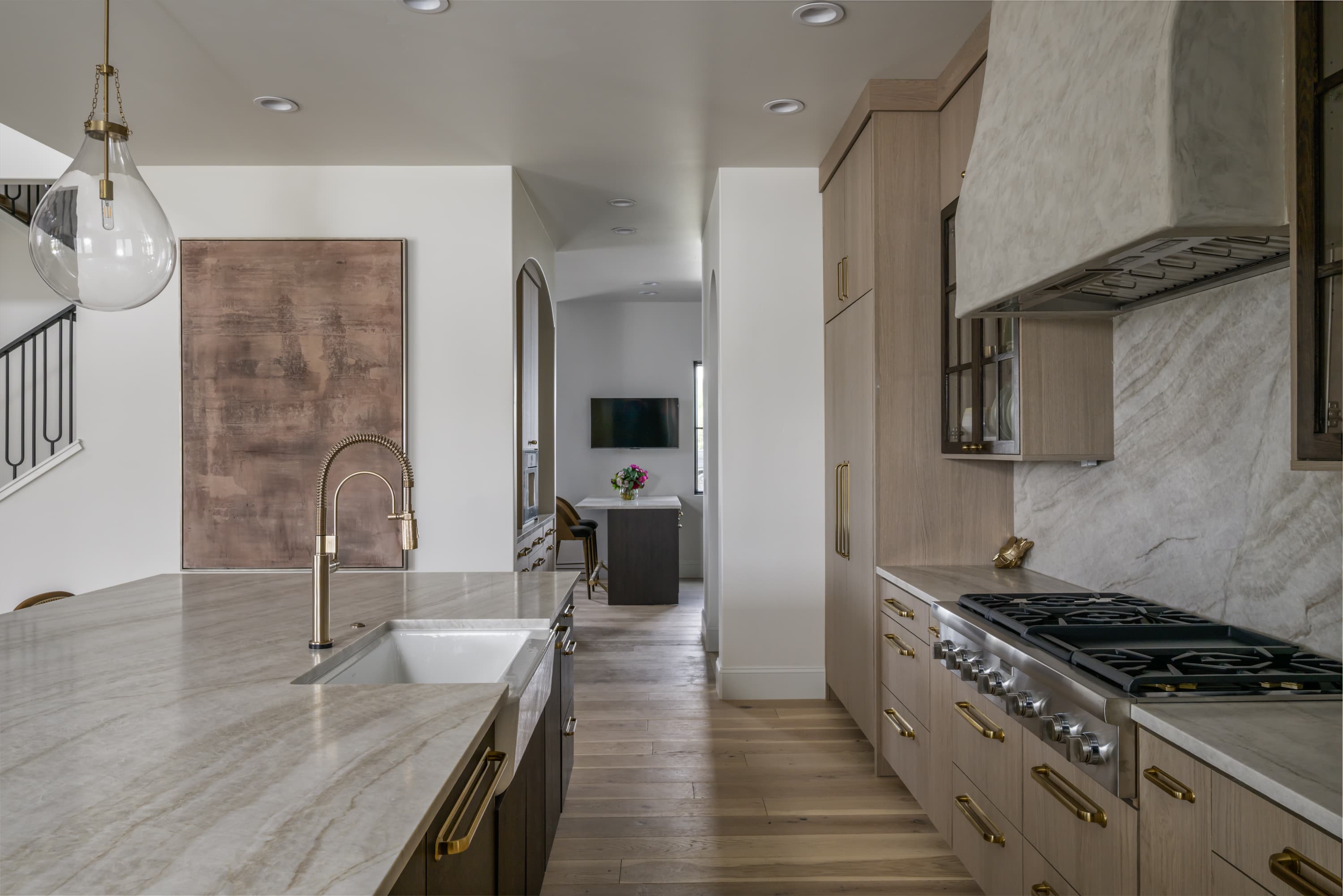 Quartzite kitchen with gold fixtures and marble backsplash